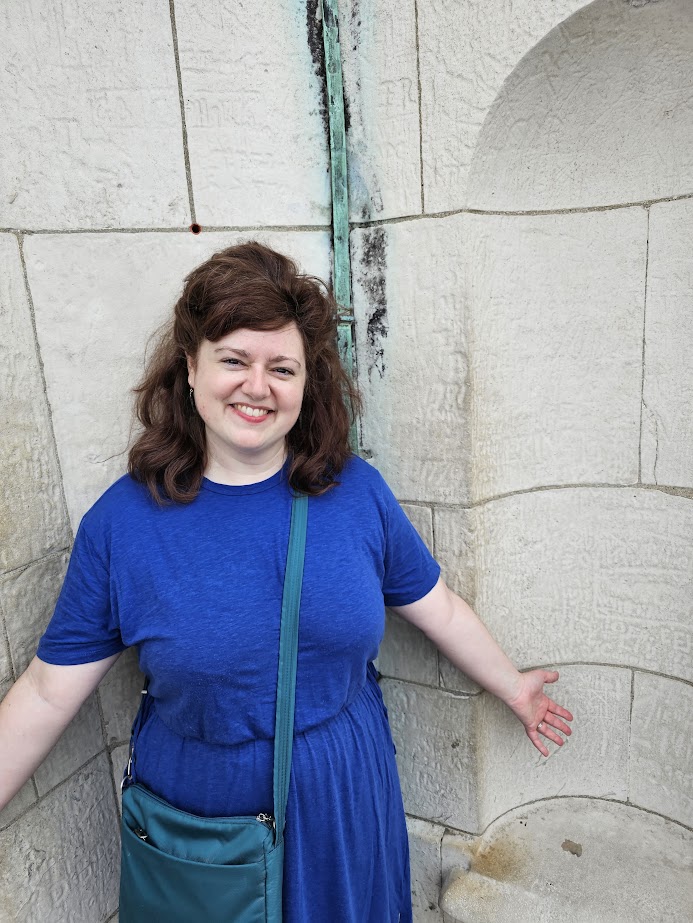 an image of Emily standing in front of a wall